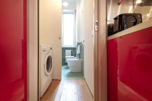 baño con lavadora en un pasillo rojo en [Buenos Aires Residence] - Stazione Centrale, en Milán