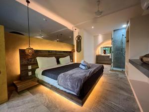 um quarto com uma cama grande e uma cabina de duche ao nível do chão em Kuun Taak Tulum em Tulum