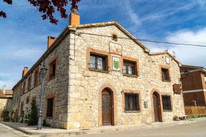 an old stone building on the corner of a street at Doña Elvira y Doña Sol in Vivar del Cid