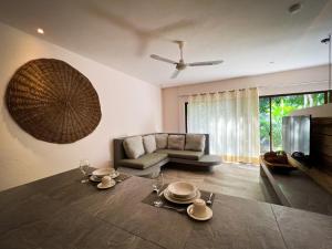 a living room with a table and a couch at Kuun Taak Tulum in Tulum