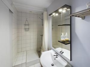 uma casa de banho branca com um lavatório e um chuveiro em Studio Deschainets Troyes Gare et Centre Historique em Troyes