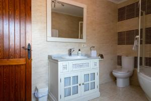 a bathroom with a sink and a toilet and a mirror at Doña Elvira y Doña Sol in Vivar del Cid