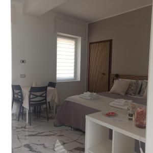 1 dormitorio con 1 cama, mesa y sillas en A Casa Mia 2.0, en Saronno