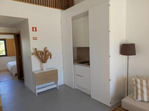 una cucina con armadi bianchi e un tavolo in una stanza di Ocean & Countryside Apartments a Encarnação