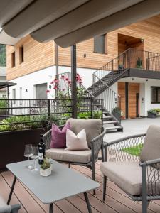 eine Terrasse mit 2 Stühlen und einem Tisch in der Unterkunft AHRN Natur Apartment in Luttach