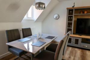 a dining room with a table and a television at The Old Barn Apartment in Wells next the Sea