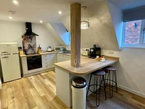 a kitchen with a counter and a refrigerator at The Old Barn Apartment in Wells next the Sea