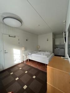 um quarto com uma cama grande e uma cozinha em Sjøberg Ferie og Hotell em Østhusvik