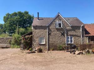 a stone house with a picnic table in front of it at The Bothy at Oak Farm in Usk