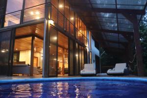 a house with a swimming pool in front of a building at Corcovado Private Villas - Corcovado Private Reserve in Puerto Jiménez