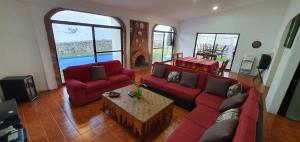 a living room with red couches and a coffee table at Casa en lomas de Cocoyoc in Texcalpan