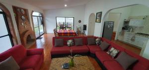 a living room with a red couch and a table at Casa en lomas de Cocoyoc in Texcalpan