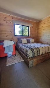 1 dormitorio con 1 cama grande en una cabaña de madera en Peumayenlodge, en Antuco