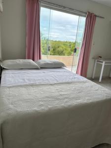 Ce lit se trouve dans une chambre dotée d'une grande fenêtre. dans l'établissement Sítio Encanto do Delta, à Tutóia