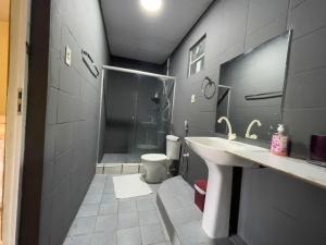 La salle de bains est pourvue d'une douche, d'un lavabo et de toilettes. dans l'établissement Sítio Encanto do Delta, à Tutóia
