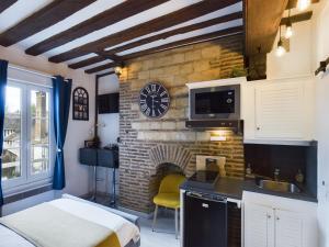uma cozinha com uma parede de tijolos e um relógio em Studio Deschainets Troyes Gare et Centre Historique em Troyes