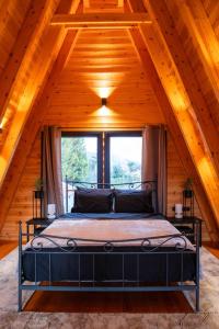 um quarto com uma cama num sótão de madeira em TO SPITI MOU em Drama
