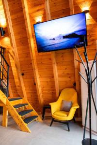 a living room with a tv and a yellow chair at KOVU chalet in Drama