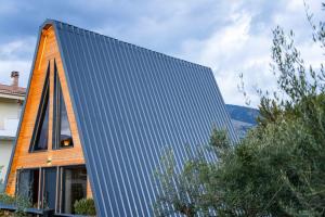 a house clad in blue solar panels on the side of it at KOVU chalet in Drama