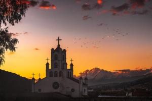 a church with a cross on top of it at sunset at Amplias y Centricas Habitaciones Huaraz WIFI, AGUA CALIENTE in Huaraz