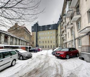 a snow covered street with cars parked on it at River view Cathedral Apartment in Vilnius