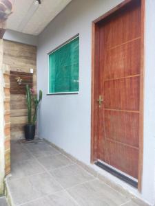 a wooden door in a hallway with a plant at Casa Nova Centro de Penedo in Penedo