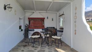a room with chairs and a table and a fireplace at Spacious apartment with view and garden for kids! in Tinos Town