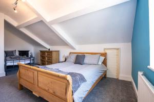 a bedroom with a wooden bed and a blue wall at Newcastle-gateshead Stylish, Spacious House in Gateshead
