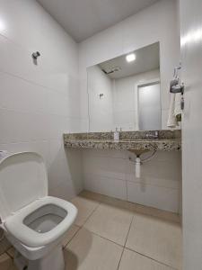 a bathroom with a toilet and a sink and a mirror at Um charme de AP Praia do Forte! (103) in Cabo Frio +17 photos