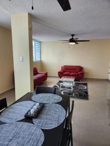 - une salle à manger avec une table, des chaises et un canapé dans l'établissement Encanto Caribeño en Levittown Lakes Puerto Rico, à Levittown