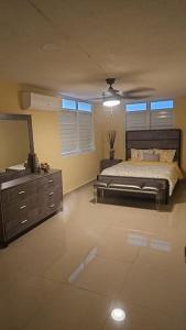 - une chambre avec un lit, une commode et un miroir dans l'établissement Encanto Caribeño en Levittown Lakes Puerto Rico, à Levittown