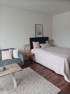 a bedroom with a large bed and a couch at Viihtyisä ja valoisa yksiö keskustan läheisyydessä in Heinola
