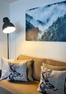 un divano con cuscini e una foto di un cervo di Ski paradise - Cielo alto Cervinia a Breuil-Cervinia