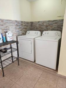 two washing machines and a table in a room at Encanto Caribeño en Levittown Lakes Puerto Rico in Levittown