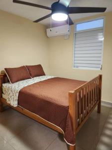 Bett in einem Schlafzimmer mit Deckenventilator in der Unterkunft Encanto Caribeño en Levittown Lakes Puerto Rico in Levittown