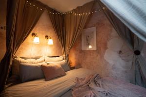 a bedroom with a canopy bed with lights on it at Pretty Jolie Romantic Getaway in Bled