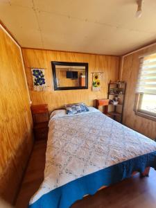 um quarto com uma cama num pequeno quarto em Cabaña Atardecer Curiñanco em Valdivia