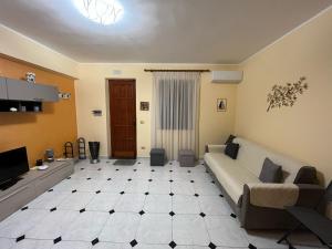 - un salon avec un canapé et une télévision dans l'établissement Appartamento Vico Matrice, à Gioiosa Marea