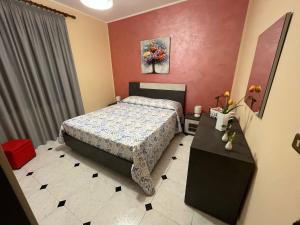 - une chambre avec un lit et une table fleurie dans l'établissement Appartamento Vico Matrice, à Gioiosa Marea