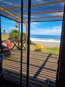 uma vista para a praia a partir do alpendre de uma casa de praia em Cabaña Atardecer Curiñanco em Valdivia