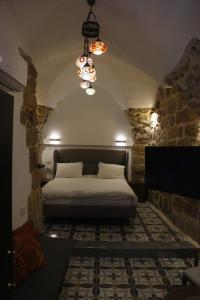 Schlafzimmer mit einem Bett und einem Kronleuchter in der Unterkunft Shafika house in Akkon