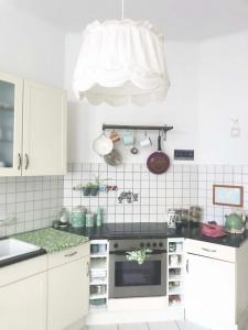 una cucina con armadi bianchi e piano cottura di Großes, helles Zimmer mit privatem Bad in Villa a Gotha