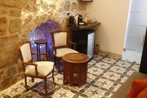 a room with two chairs and a table and a fireplace at Shafika house in ‘Akko