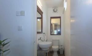 a bathroom with a sink and a toilet and a mirror at 519@jamtree in Colombo