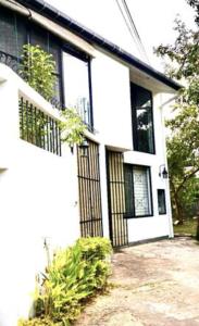 a white house with black doors and windows at 519@jamtree in Colombo