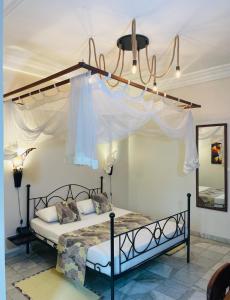 a bedroom with a bed with a canopy at Le Lodge des Almadies in Dakar