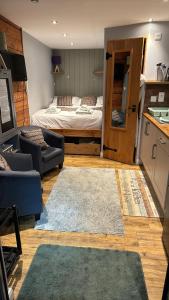 a living room with a bed and a couch and a kitchen at Nadurra But and Ben - Where the Ordinary Becomes Extraordinary in Fort William