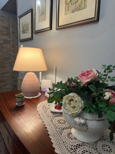 uma mesa com um candeeiro e um vaso com flores em Coccinella B&B a Tufo em Tufo