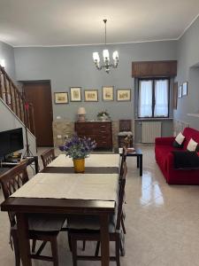 uma sala de estar com uma mesa e um sofá vermelho em Coccinella B&B a Tufo em Tufo