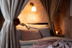 a bedroom with a bed with curtains and a lamp at Pretty Jolie Romantic Getaway in Bled